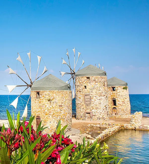 A traditional Chios village with windmills, geometrically patterned houses, and cobbled streets.